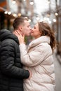Happy man kissing his woman in the street. The guy in love takes care of the girl. Couple enjoying life outdoors Royalty Free Stock Photo