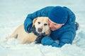 A happy man with a Labrador retriever dog lying in the snow Royalty Free Stock Photo