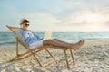 Happy man with laptop talking by mobile phone on beach. Business trip Royalty Free Stock Photo