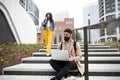 Happy man with laptop using laptop on the way to work outdoors in city, coronavirus concept. Royalty Free Stock Photo