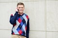 Happy man leaning against wall with cell phone Royalty Free Stock Photo