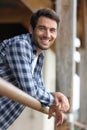 happy man leaning on fence at stable Royalty Free Stock Photo