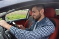 Happy man looks into the phone in the car Royalty Free Stock Photo