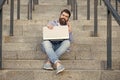 Happy man making mobile call relaxing on stairs outdoors. Smiling man talking on mobile phone Royalty Free Stock Photo