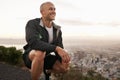 Happy man, mountain and fitness in nature by the city for workout, exercise or outdoor training. Young male person or Royalty Free Stock Photo