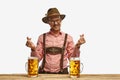 Happy man with mustaches wearing traditional german outfit with beer showing heart symbol, shape feelings. Concept of Royalty Free Stock Photo