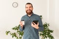 Happy man in office holding tablet and cup of coffee take away Royalty Free Stock Photo
