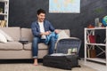 Happy man packing clothes into travel bag Royalty Free Stock Photo