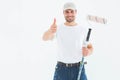 Happy man with paint roller gesturing thumbs up