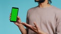 Happy man pointing towards green screen mobile phone, showing thumbs up sign Royalty Free Stock Photo