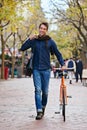 Happy man, portrait and push bicycle in city to travel on eco friendly transport outdoor, commute and trip. Cycling Royalty Free Stock Photo