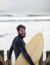 Happy man, portrait and surfer on beach for fitness, sport or waves on shore in outdoor exercise. Young male person with Royalty Free Stock Photo