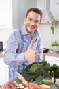 Happy man posing with vegetables in the kitchen - thumbs up Royalty Free Stock Photo