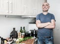 Happy man in the prime of life in kitchen prepared two salads