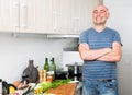 Happy man in the prime of life in kitchen prepared two salads Royalty Free Stock Photo