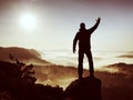 Happy man with raised arms gesture triumph on exposed cliff. Satisfy hiker Royalty Free Stock Photo