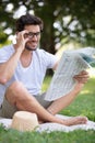 happy man reading newspaper on grass Royalty Free Stock Photo