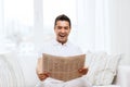 Happy man reading newspaper and laughing at home Royalty Free Stock Photo