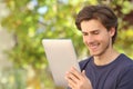 Happy man reading a tablet reader outdoors Royalty Free Stock Photo