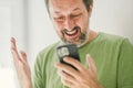 Happy man received satisfying text message on mobile smartphone Royalty Free Stock Photo