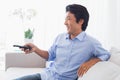 Happy man relaxing on couch watching tv Royalty Free Stock Photo