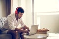 Happy man relaxing on the sofa listening to music with laptop at home Royalty Free Stock Photo