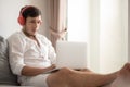 Happy man relaxing on the sofa listening to music with laptop at home Royalty Free Stock Photo