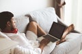 Happy man relaxing on the sofa listening to music with laptop at home Royalty Free Stock Photo