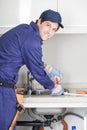 Happy man repairing de sink