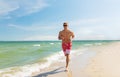 Happy man running along summer beach Royalty Free Stock Photo