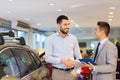 Happy man shaking hands in auto show or salon Royalty Free Stock Photo