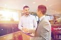 Happy man shaking hands in auto show or salon Royalty Free Stock Photo