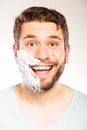 Happy man with shaving cream foam on half of face. Royalty Free Stock Photo