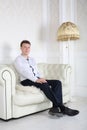 Happy man in shirt sits on sofa and dreams Royalty Free Stock Photo