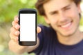 Happy man showing a blank mobile phone screen outdoor Royalty Free Stock Photo