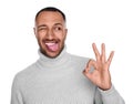 Happy young man showing his tongue and OK gesture on white background Royalty Free Stock Photo