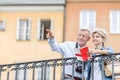 Happy man showing something to woman with guidebook in city