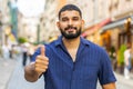 Happy man showing thumbs up, like sign positive something good positive feedback in city street