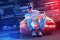 Happy man sitting in a bean bag chair and enjoying playing video games Royalty Free Stock Photo