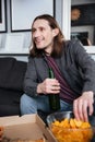 Happy man sitting at home indoors eating crisps. Royalty Free Stock Photo