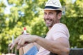 happy man sitting on park bench with cigarette Royalty Free Stock Photo