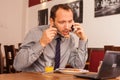 Happy man sitting in restaurant with laptop Royalty Free Stock Photo