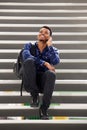 Happy man sitting on steps talking on mobile phone Royalty Free Stock Photo