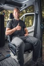 Happy man sitting in a swivel seat inside his van