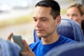 Happy man sitting in travel bus with smartphone Royalty Free Stock Photo