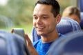 Happy man sitting in travel bus with smartphone Royalty Free Stock Photo