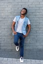 Happy man smiling with headphones leaning against wall Royalty Free Stock Photo