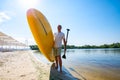 Happy man is standing with a SUP board on beach Royalty Free Stock Photo