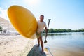Happy man is standing with a SUP board on beach Royalty Free Stock Photo