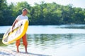 Happy man is standing with a SUP board Royalty Free Stock Photo